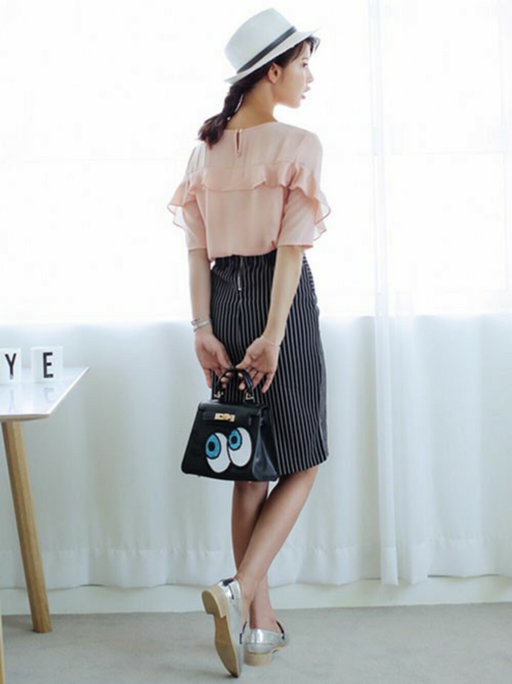 ピンク系のシャツ/ブラウス、ブラック系のスカートを着用したレディースの春コーディネートの1枚目の写真