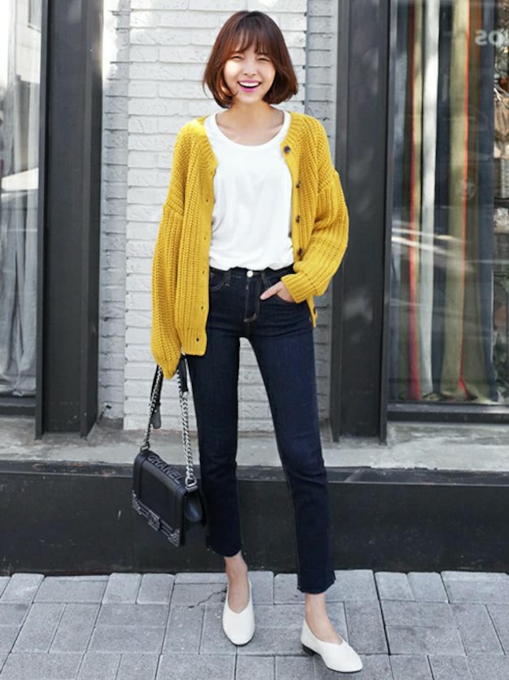 ホワイト系のパンプス、その他のデニムパンツ、イエロー系のカーディガン/ボレロを着用したレディースの秋コーディネートの1枚目の写真