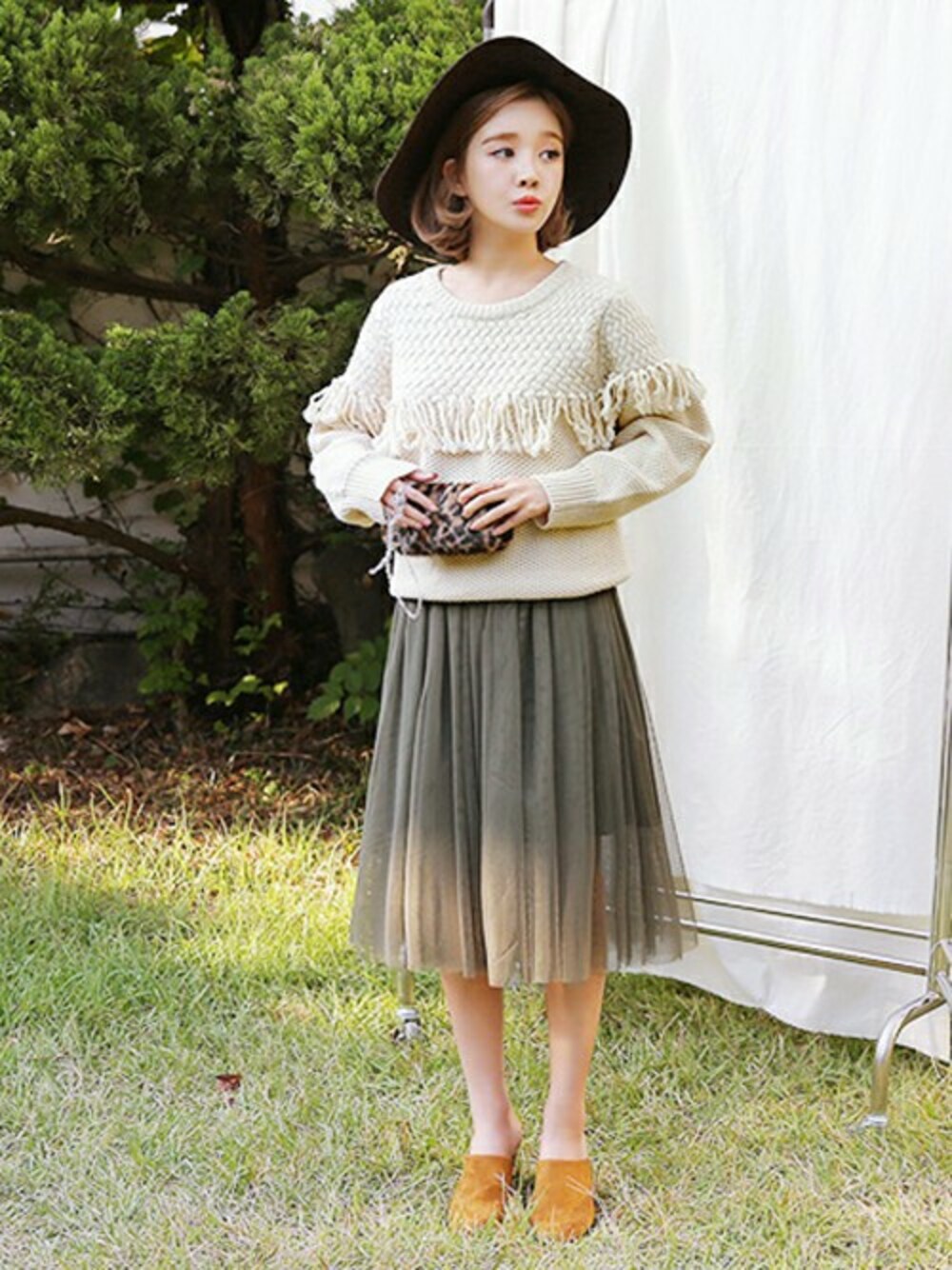 ブラウン系のサンダル、グリーン系のスカート、ベージュ系のニット/セーターを着用したレディースの秋コーディネートの1枚目の写真