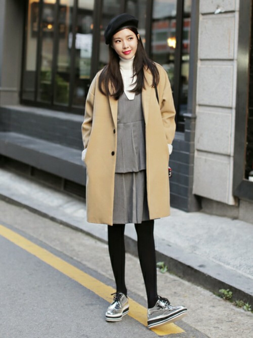 シルバー系のドレスシューズ、ベージュ系のチェスターコート、ブラック系のニット/セーターを着用したレディースの秋コーディネートの1枚目の写真