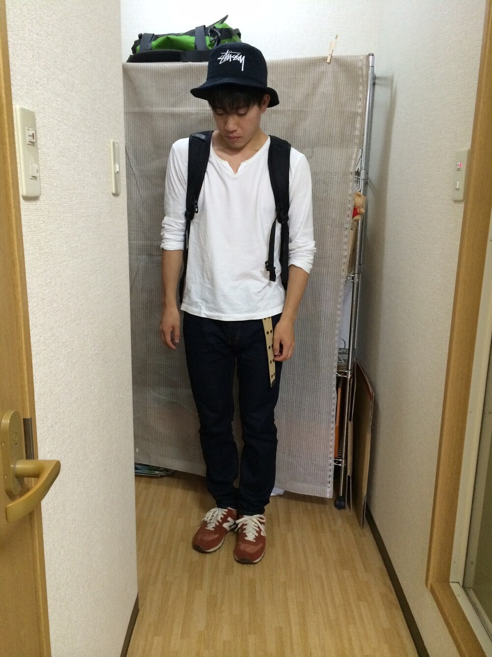 レッド系のスニーカー、ブラック系のハットを着用したメンズの夏コーディネートの1枚目の写真