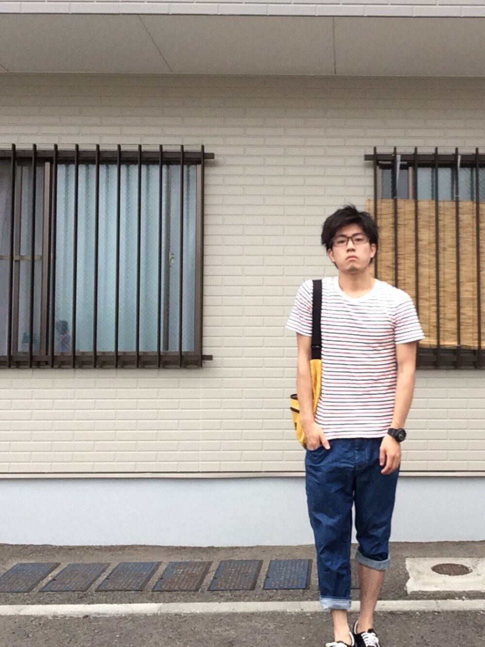 ブラック系のスニーカー、イエロー系のショルダーバッグ、ブラック系のアナログ腕時計を着用したメンズの夏コーディネートの1枚目の写真