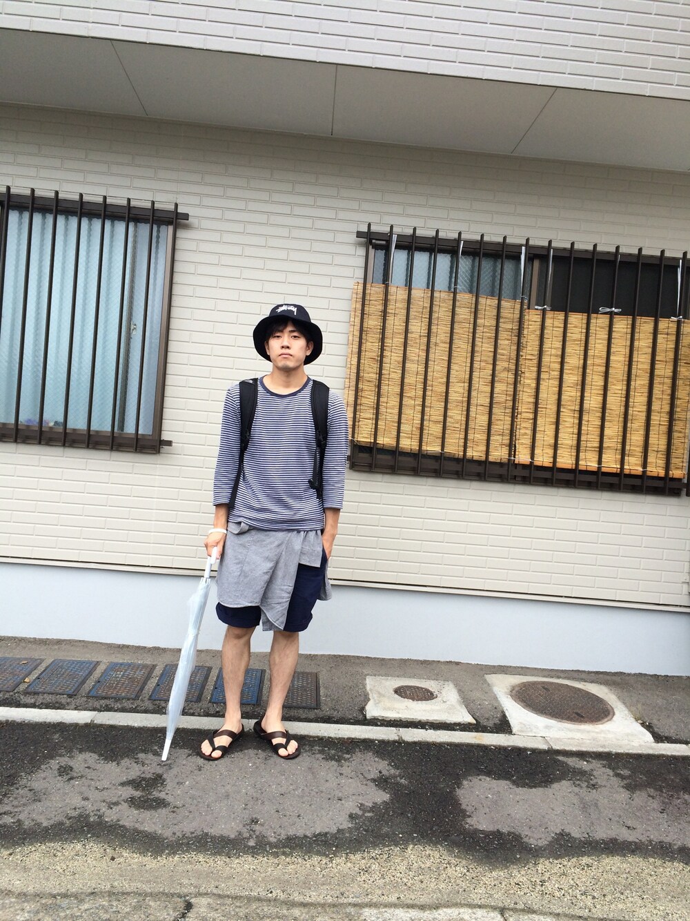 ブラック系のサンダル、ブラック系のハットを着用したメンズの夏コーディネートの1枚目の写真