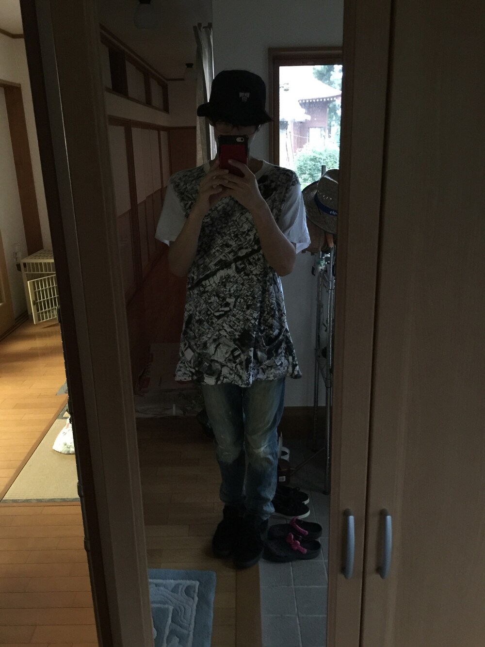 ホワイト系のTシャツ/カットソー、ブルー系のデニムパンツ、ブラック系のスニーカーを着用したメンズの秋コーディネートの1枚目の写真