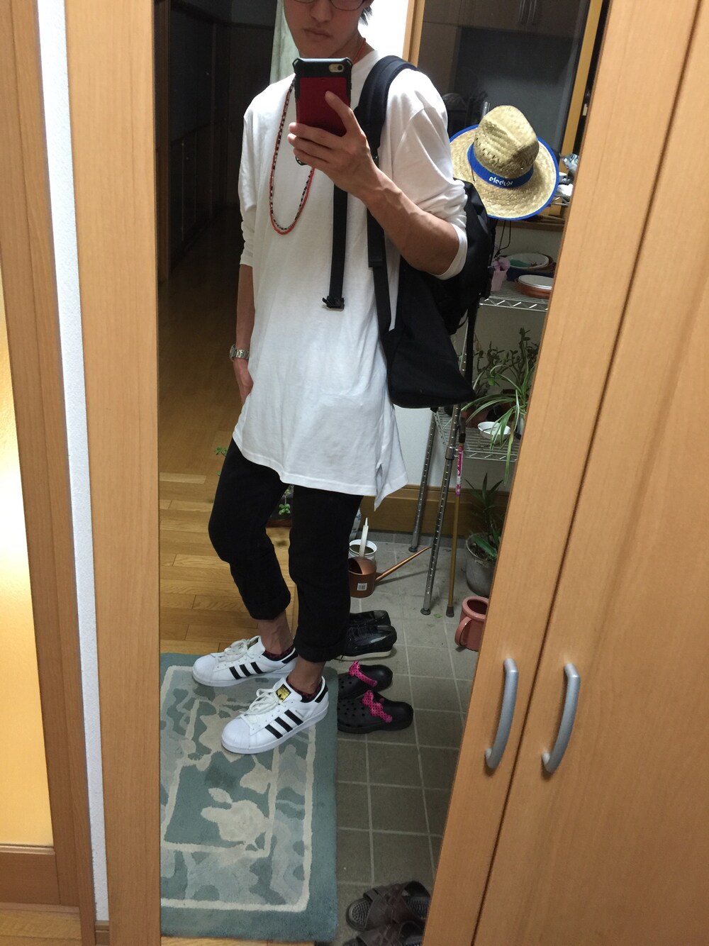 ホワイト系のTシャツ/カットソー、ブラック系のデニムパンツ、ホワイト系のスニーカーを着用したメンズの秋コーディネートの1枚目の写真