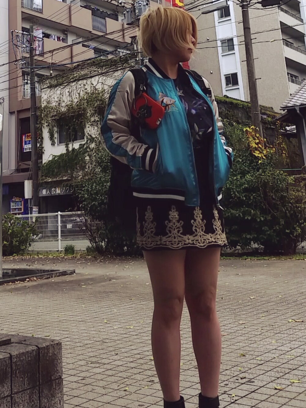 ブラック系のスカート、ブラック系のバックパック/リュック、ブラック系のブーティを着用したレディースの秋コーディネートの1枚目の写真