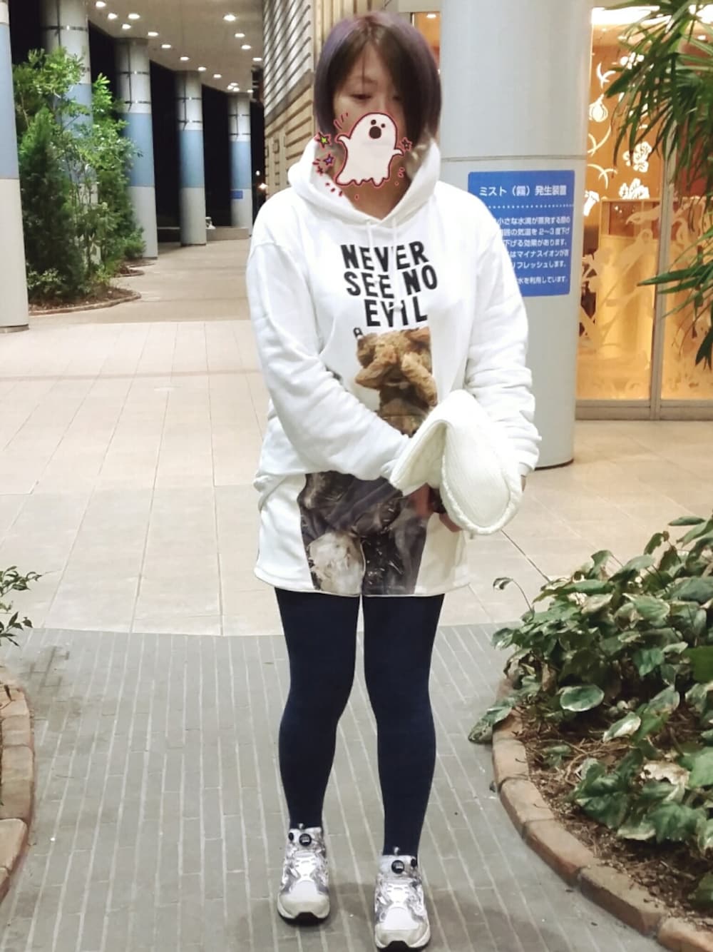 ホワイト系のクラッチバッグ、ホワイト系のパンツ、グレー系のスニーカーを着用したレディースの冬コーディネートの1枚目の写真