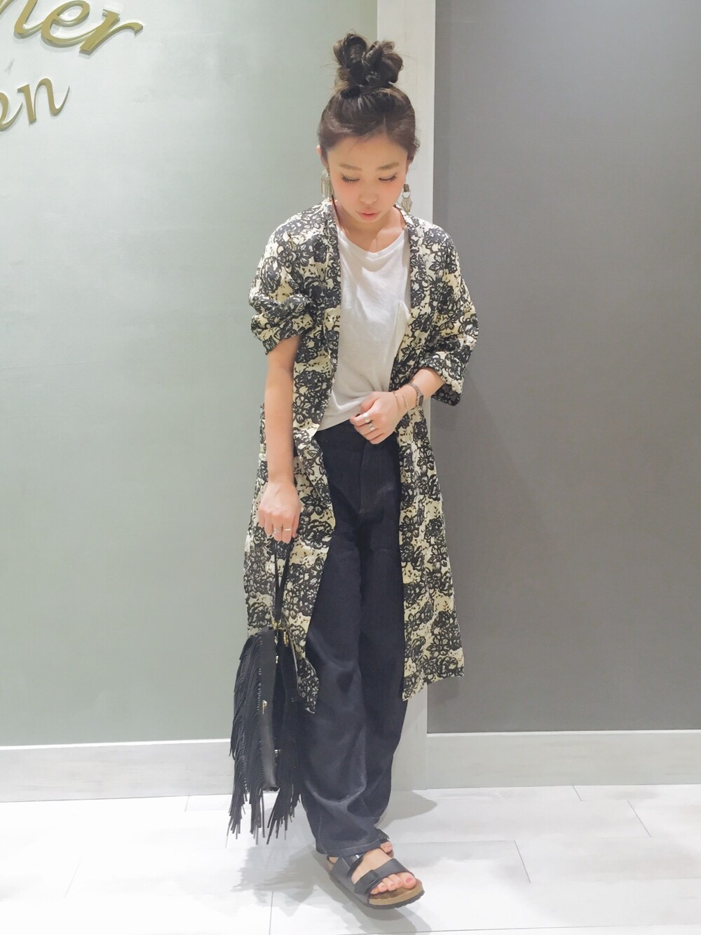 ブラック系のカーディガン/ボレロ、ホワイト系のTシャツ/カットソー、ブラック系のショルダーバッグを着用したレディースの春コーディネートの1枚目の写真