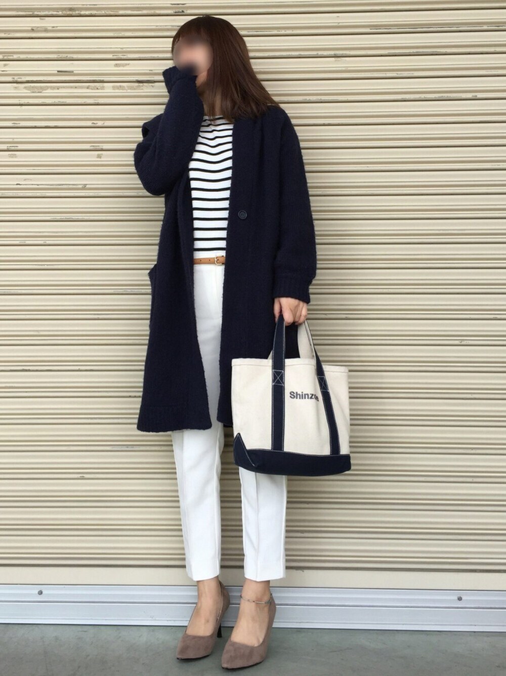 ブルー系のトートバッグ、ブルー系のニット/セーター、ホワイト系のTシャツ/カットソーを着用したレディースの冬コーディネートの1枚目の写真