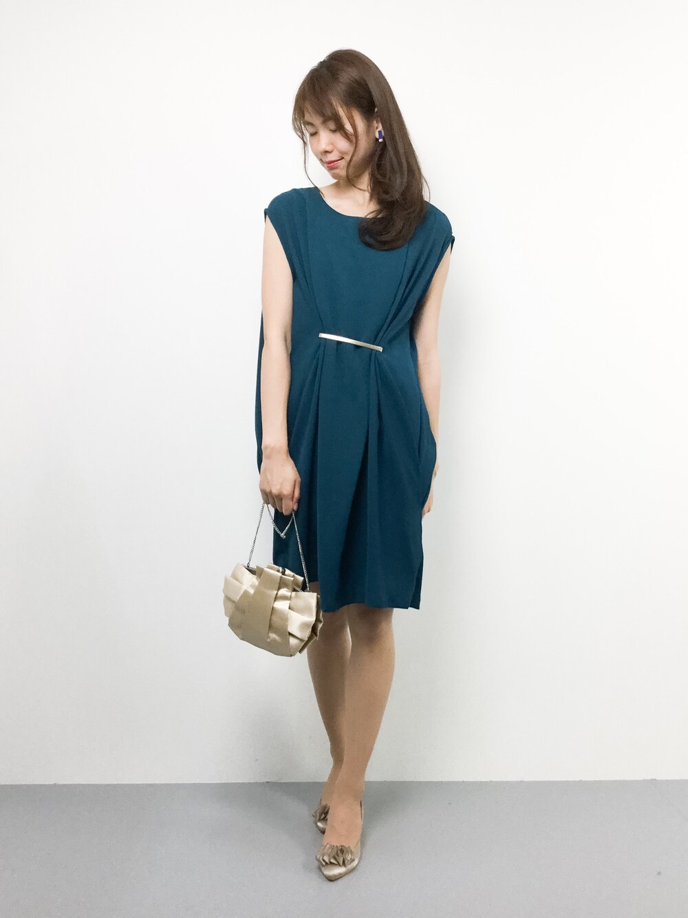 ブルー系のワンピース、ベージュ系のクラッチバッグを着用したレディースの秋コーディネートの1枚目の写真