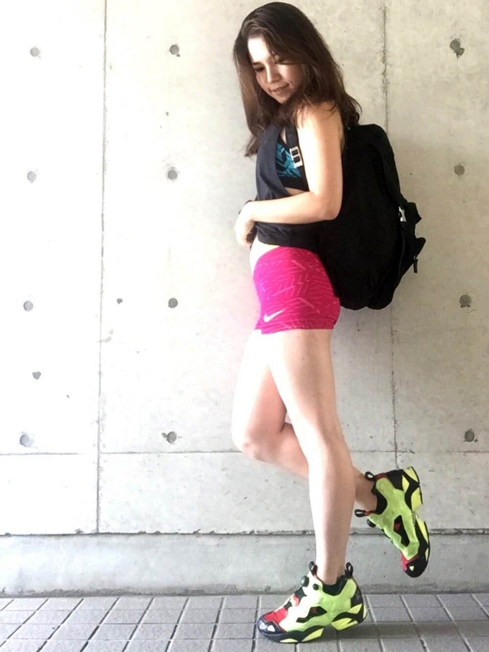 ピンク系のパンツ、イエロー系のスニーカー、ブラック系のタンクトップを着用したレディースの夏コーディネートの1枚目の写真
