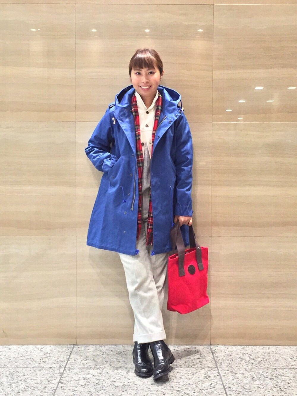ブルー系のモッズコート、ホワイト系のブルゾン、レッド系のトートバッグを着用したレディースの秋コーディネートの1枚目の写真