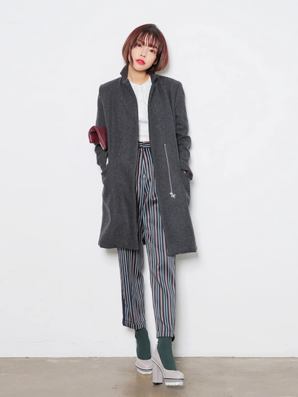 グリーン系のその他パンツ、レッド系のクラッチバッグ、グレー系のパンプスを着用したレディースの冬コーディネートの1枚目の写真