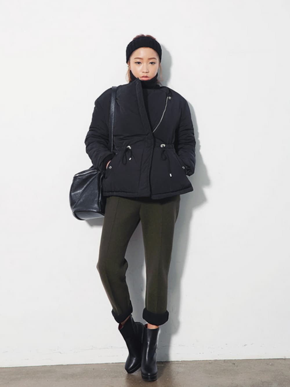 ブラック系のノーカラージャケット、ブラック系のブーツ、ブラック系のショルダーバッグを着用したレディースの冬コーディネートの1枚目の写真