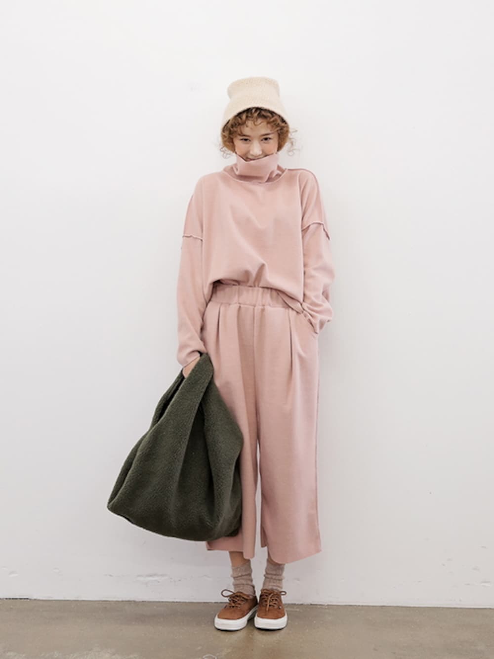 ピンク系のスウェット、グリーン系のエコバッグ/サブバッグを着用したレディースの冬コーディネートの1枚目の写真