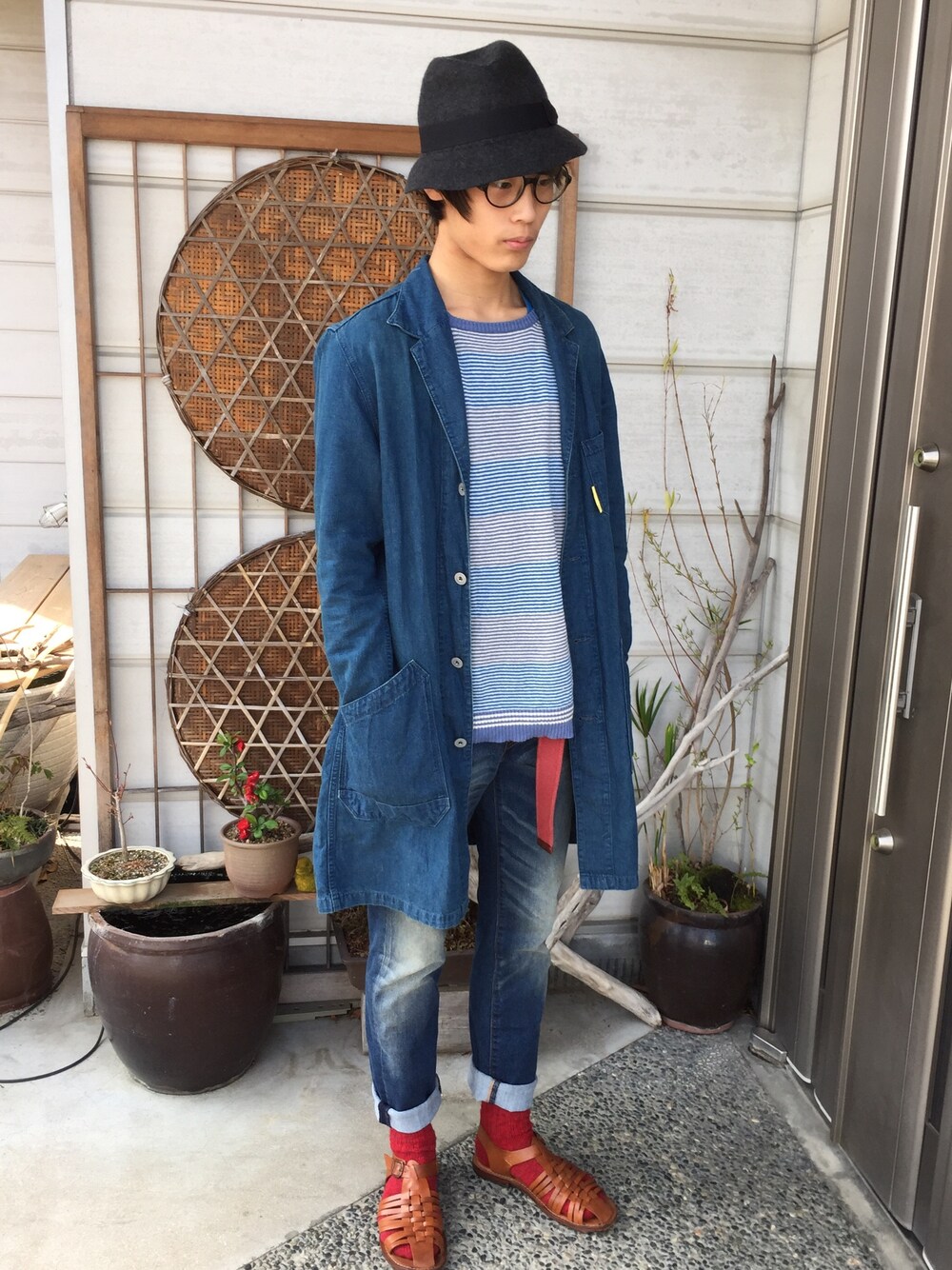 ブルー系のチェスターコート、ブルー系のニット/セーター、ブルー系のデニムパンツを着用したメンズの春コーディネートの1枚目の写真