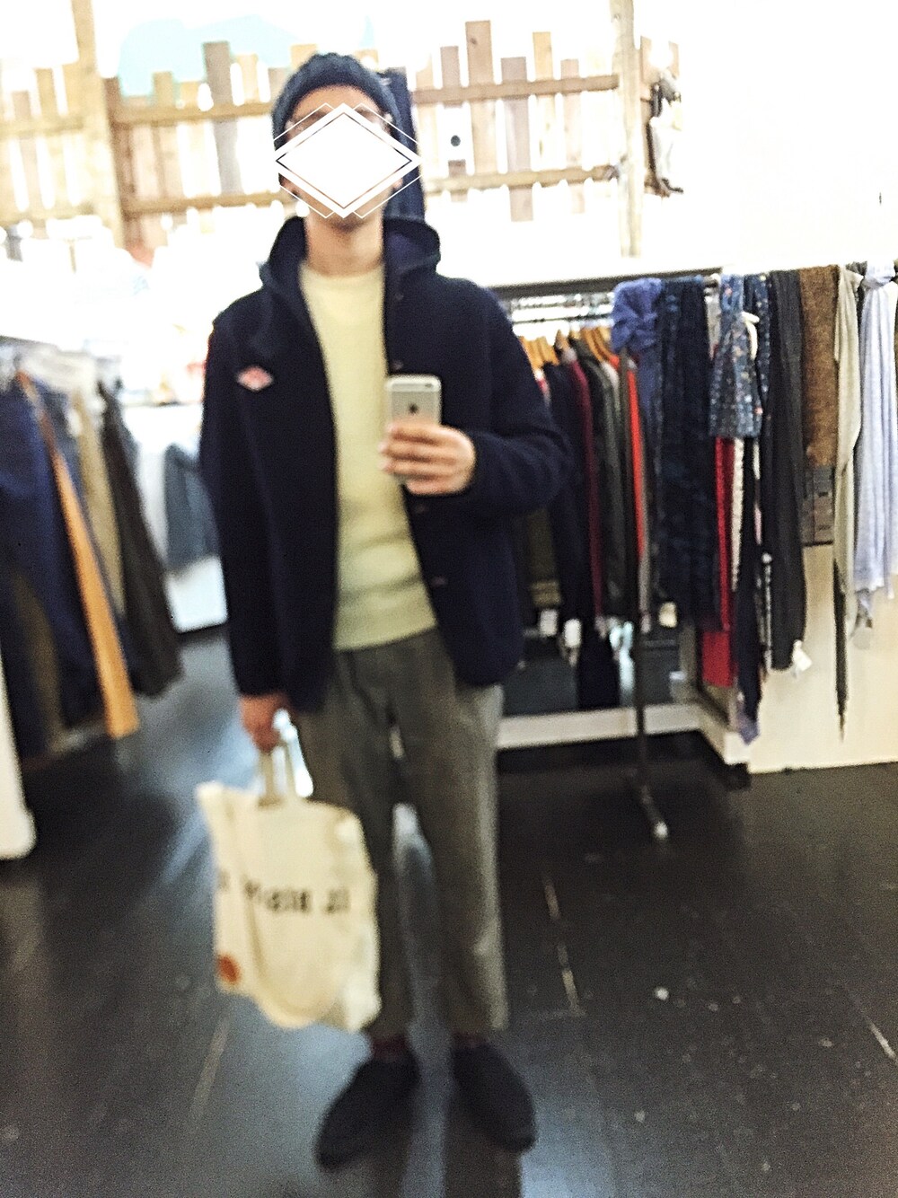 ブルー系のダッフルコート、ホワイト系のニット/セーター、ベージュ系のスラックスを着用したメンズの秋コーディネートの1枚目の写真