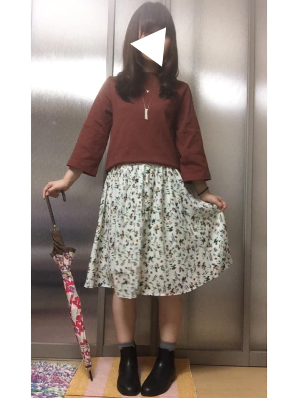 ブラック系のレインシューズ、ブラウン系のTシャツ/カットソー、ホワイト系のスカートを着用したレディースの秋コーディネートの1枚目の写真