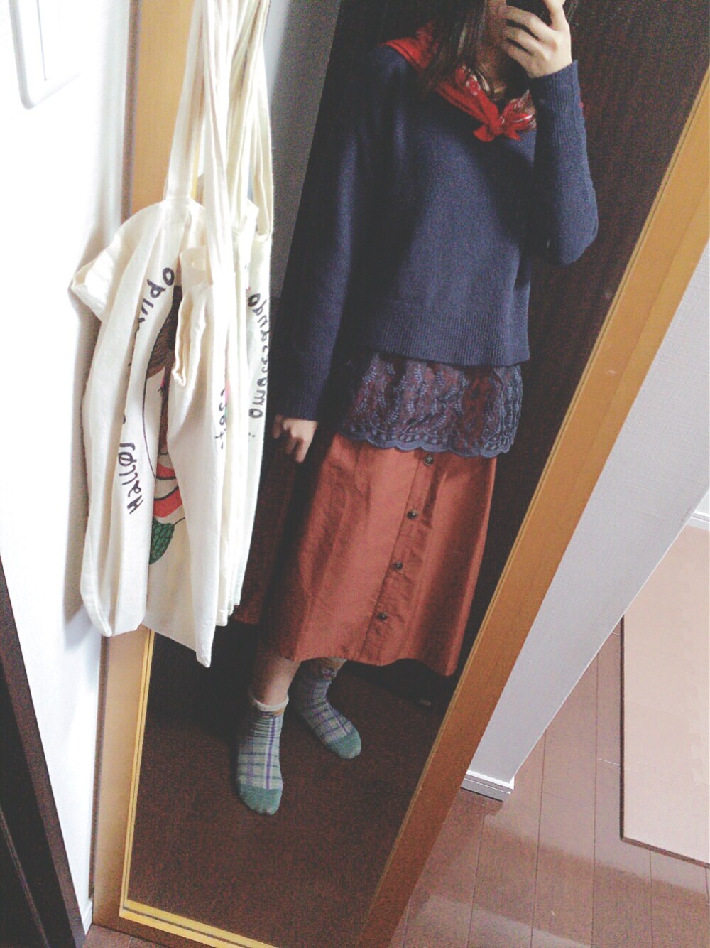 ブラウン系のスカート、ブルー系のTシャツ/カットソー、ブルー系のニット/セーターを着用したレディースの冬コーディネートの1枚目の写真