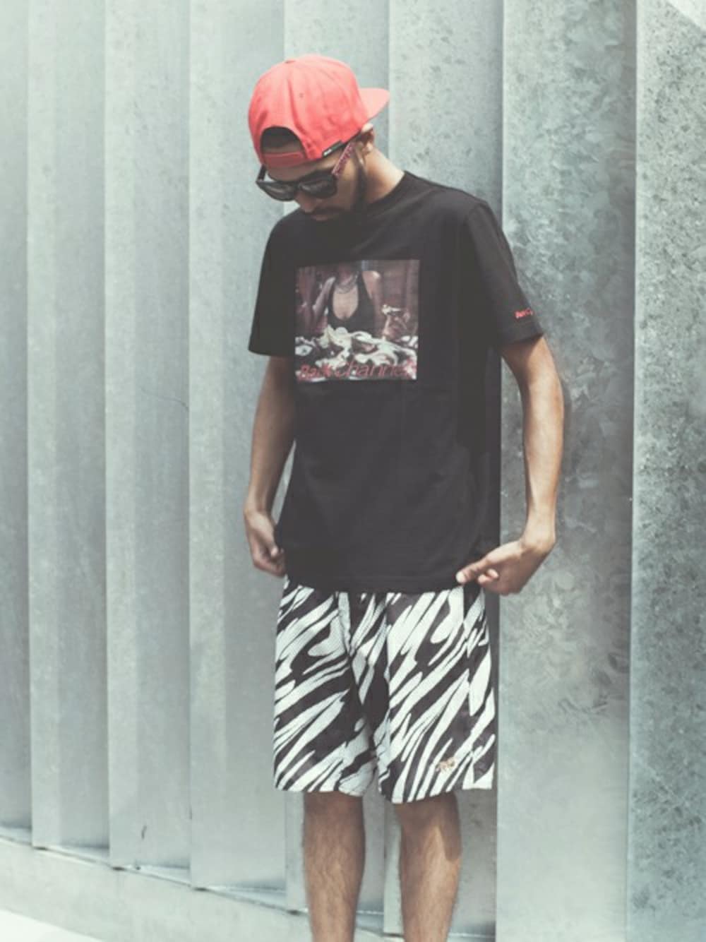 「キャップ、Tシャツ、サングラス、オールブラック、BACK CHANNEL、ショーツ、ボードショーツ」｜「Back ChannelのSTITCH LOGO SNAP BACK（キャップ、レッド系）」を使った、Back Channel®︎さん（メンズ・176cm）の夏コーディネートの1枚目の写真