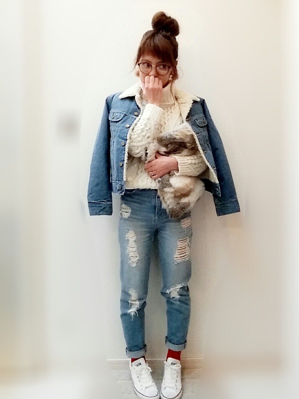 ホワイト系のニット/セーター、ホワイト系のスニーカー、ブルー系のデニムパンツを着用したレディースの冬コーディネートの1枚目の写真