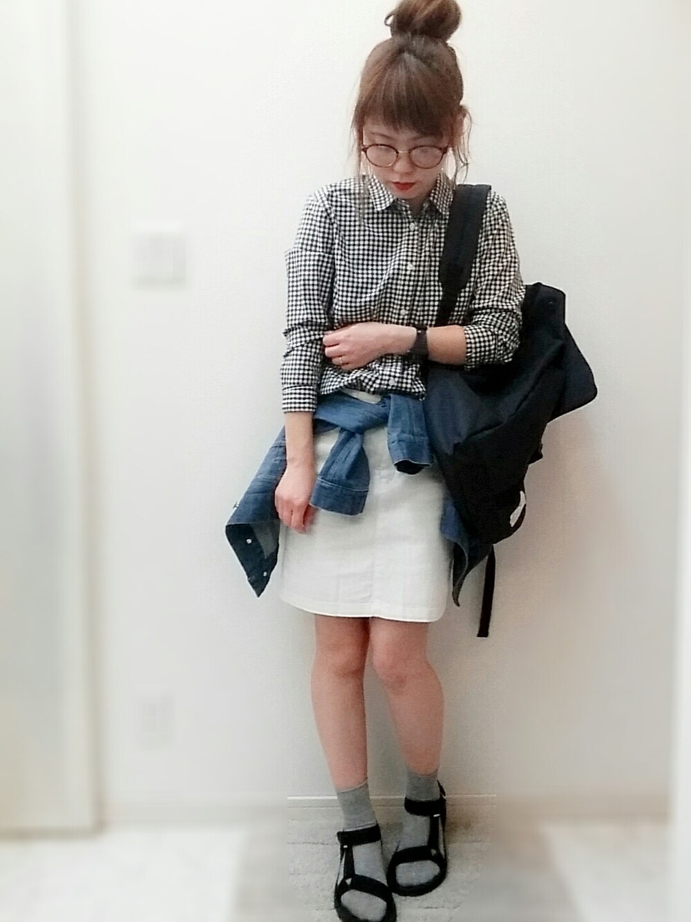 ブラック系のシャツ/ブラウス、ブルー系のデニムジャケット、ブルー系のバックパック/リュックを着用したレディースの春コーディネートの1枚目の写真