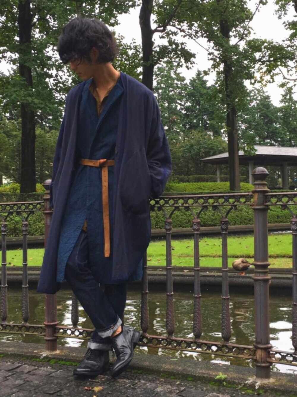 ブルー系のポンチョ、ブルー系のノーカラージャケット、ブルー系のデニムパンツを着用したメンズの秋コーディネートの1枚目の写真