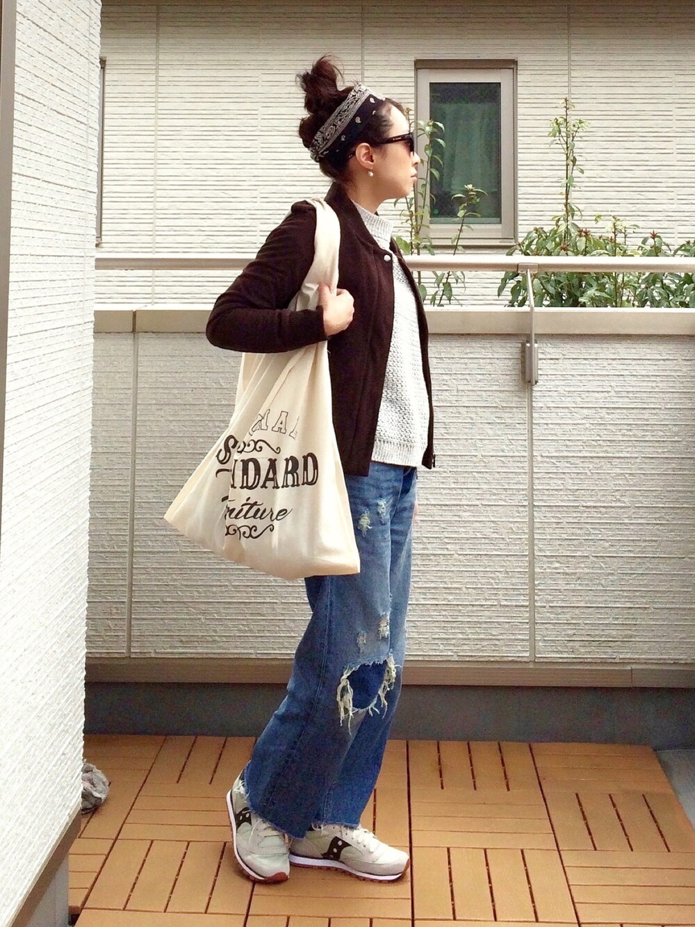 ベージュ系のスニーカー、ブルー系のデニムパンツ、グレー系のニット/セーターを着用したレディースの春コーディネートの1枚目の写真