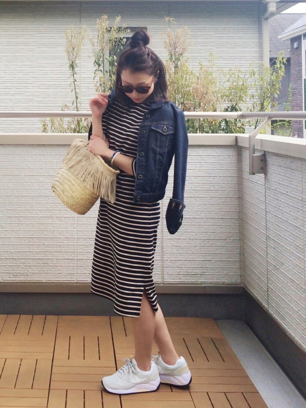 グレー系のスニーカー、ベージュ系のかごバッグ、ブルー系のワンピースを着用したレディースの春コーディネートの1枚目の写真