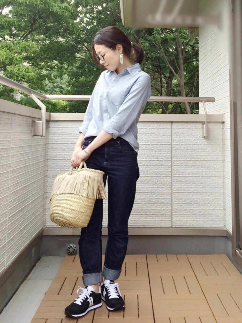 ブラック系のスニーカー、ブルー系のデニムパンツ、ブルー系のシャツ/ブラウスを着用したレディースの春コーディネートの1枚目の写真