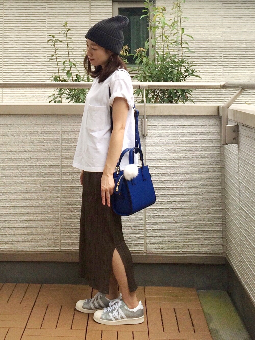 ホワイト系のスニーカー、グリーン系のスカート、ホワイト系のTシャツ/カットソーを着用したレディースの秋コーディネートの1枚目の写真
