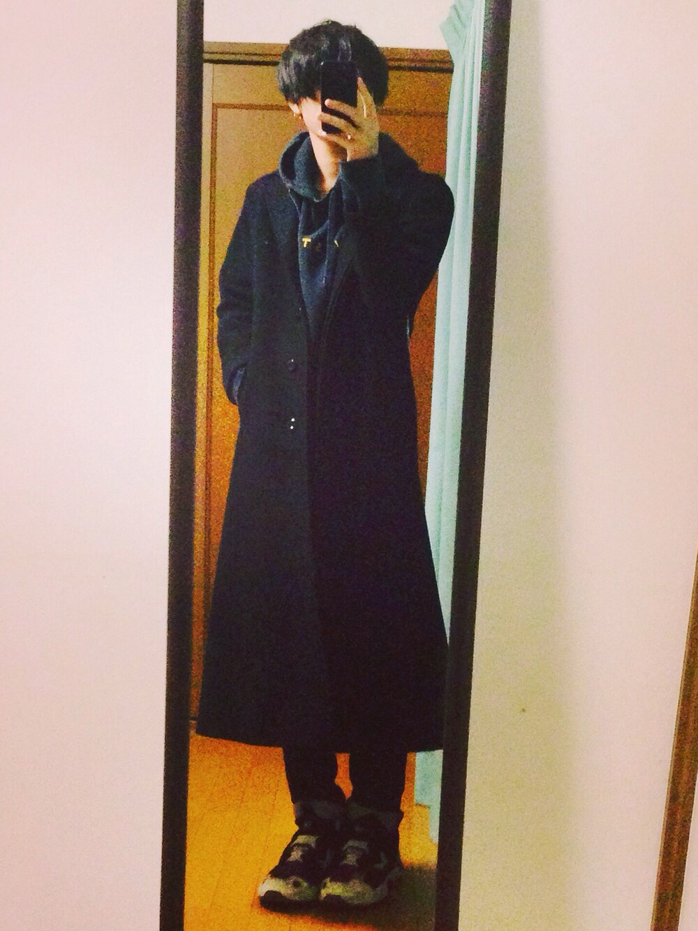 ブラック系のチェスターコートを着用したメンズの秋コーディネートの1枚目の写真