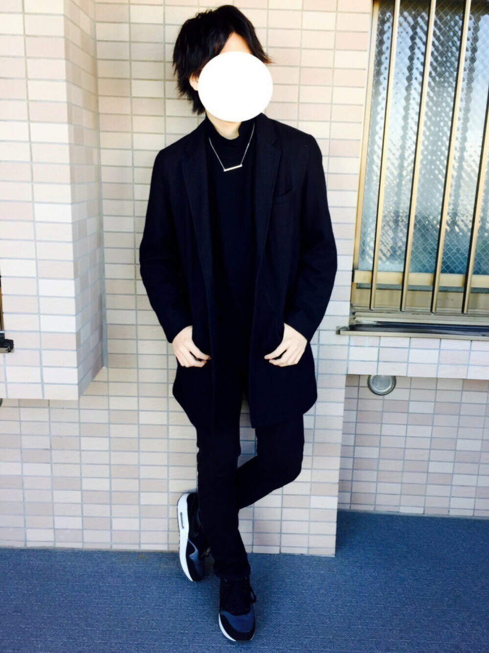 ブルー系のチェスターコート、ブラック系のトップス、ブラック系のデニムパンツを着用したメンズの冬コーディネートの1枚目の写真