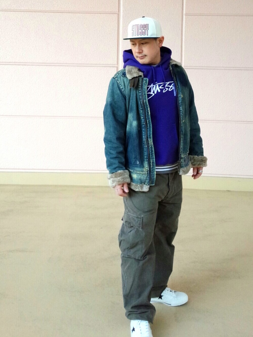 ブルー系のデニムジャケット、ホワイト系のシューズ、パープル系のパーカーを着用したメンズの冬コーディネートの1枚目の写真