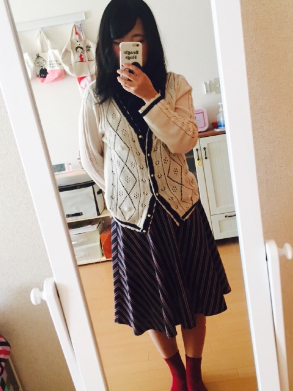 ベージュ系のカーディガン/ボレロ、ブルー系のスカート、ブルー系のポロシャツを着用したレディースの秋コーディネートの1枚目の写真