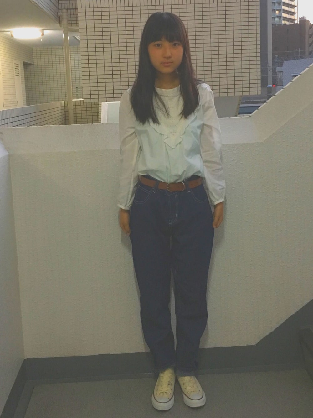 ブルー系のデニムパンツ、ベージュ系のスニーカー、ホワイト系のシャツ/ブラウスを着用したレディースの秋コーディネートの1枚目の写真