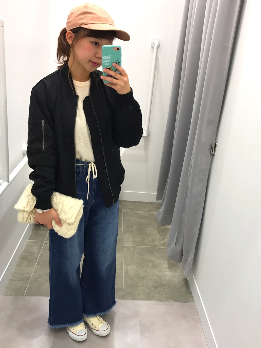 ブルー系のデニムパンツ、ピンク系のニット/セーター、ブラック系のジャケット/アウターを着用したレディースの秋コーディネートの1枚目の写真