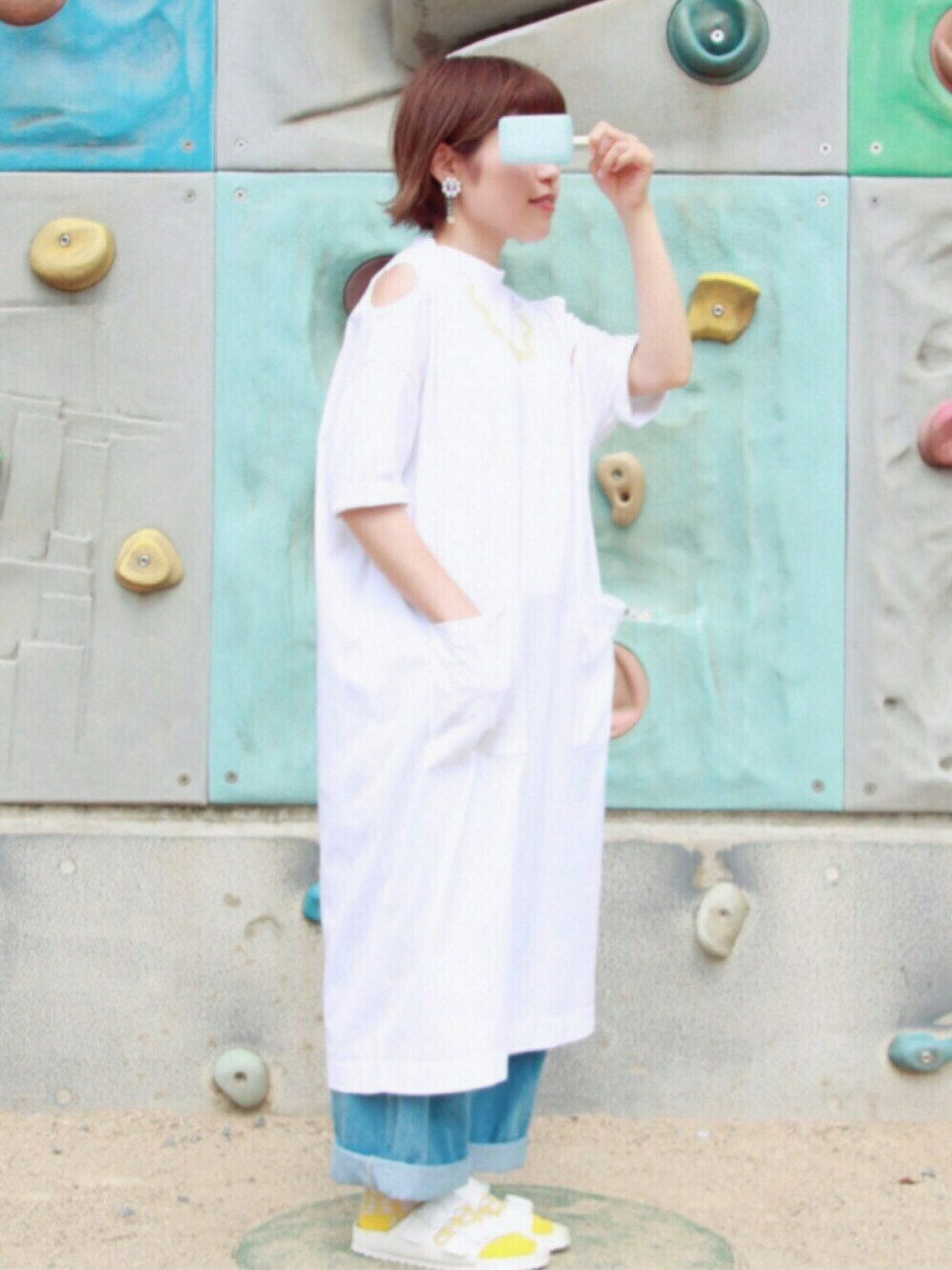 ホワイト系のワンピース、ブルー系のデニムパンツ、ホワイト系のサンダルを着用したレディースの夏コーディネートの1枚目の写真