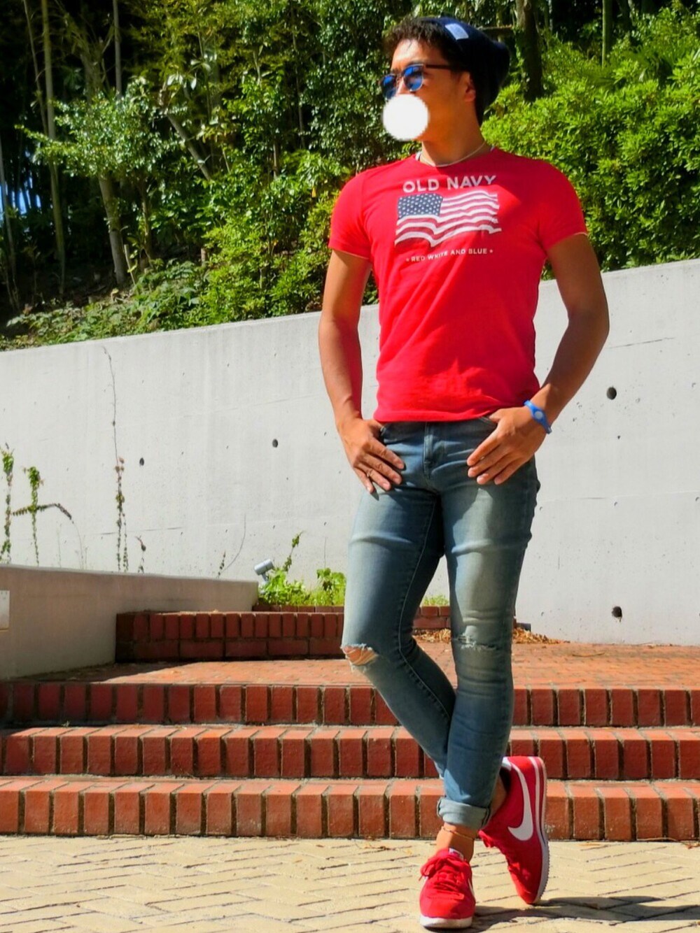 レッド系のTシャツ/カットソー、ブルー系のデニムパンツ、レッド系のスニーカーを着用したメンズの夏コーディネートの1枚目の写真