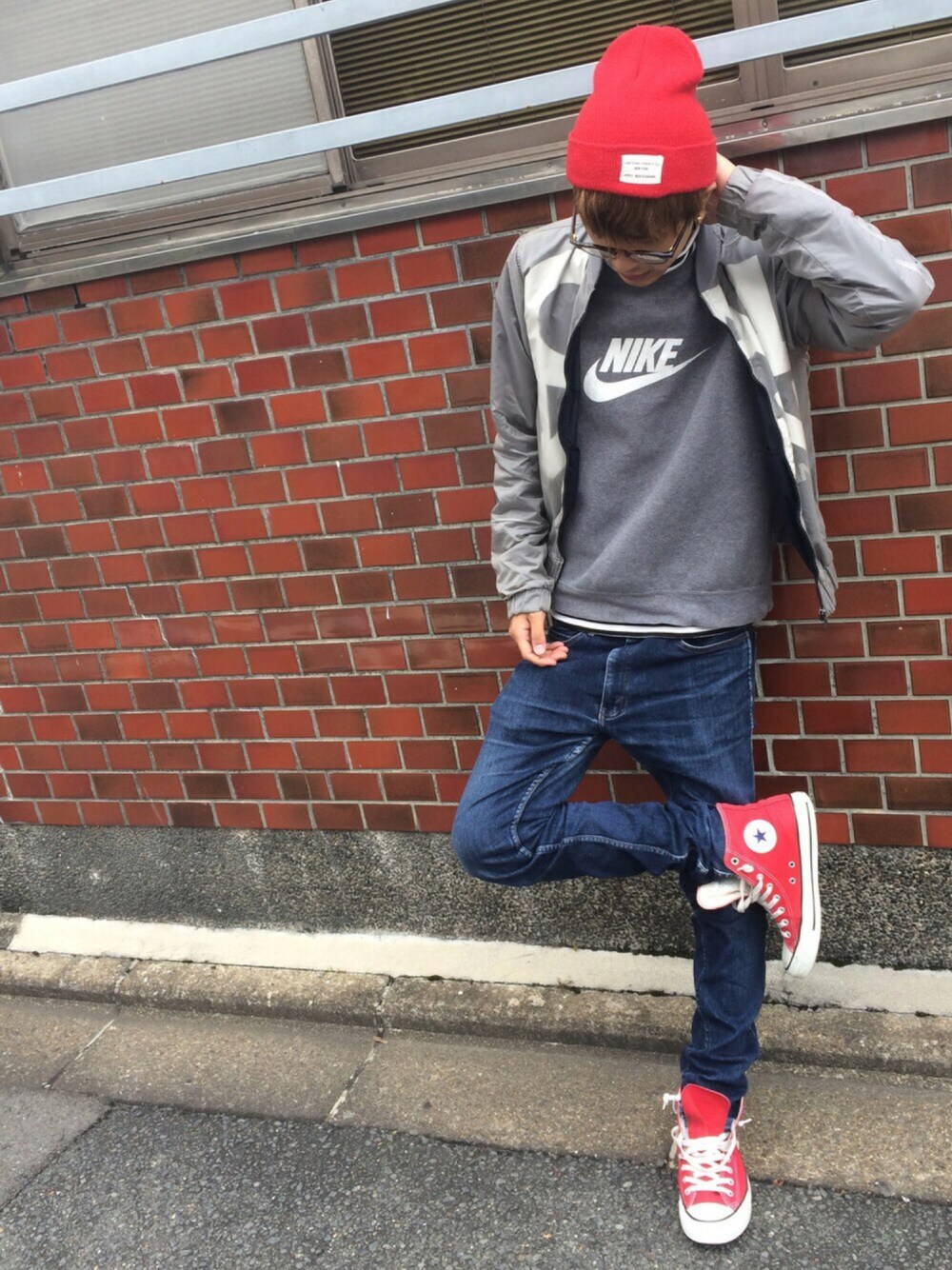 グレー系のナイロンジャケット、グレー系のスウェット、ブルー系のデニムパンツを着用したメンズの秋コーディネートの1枚目の写真