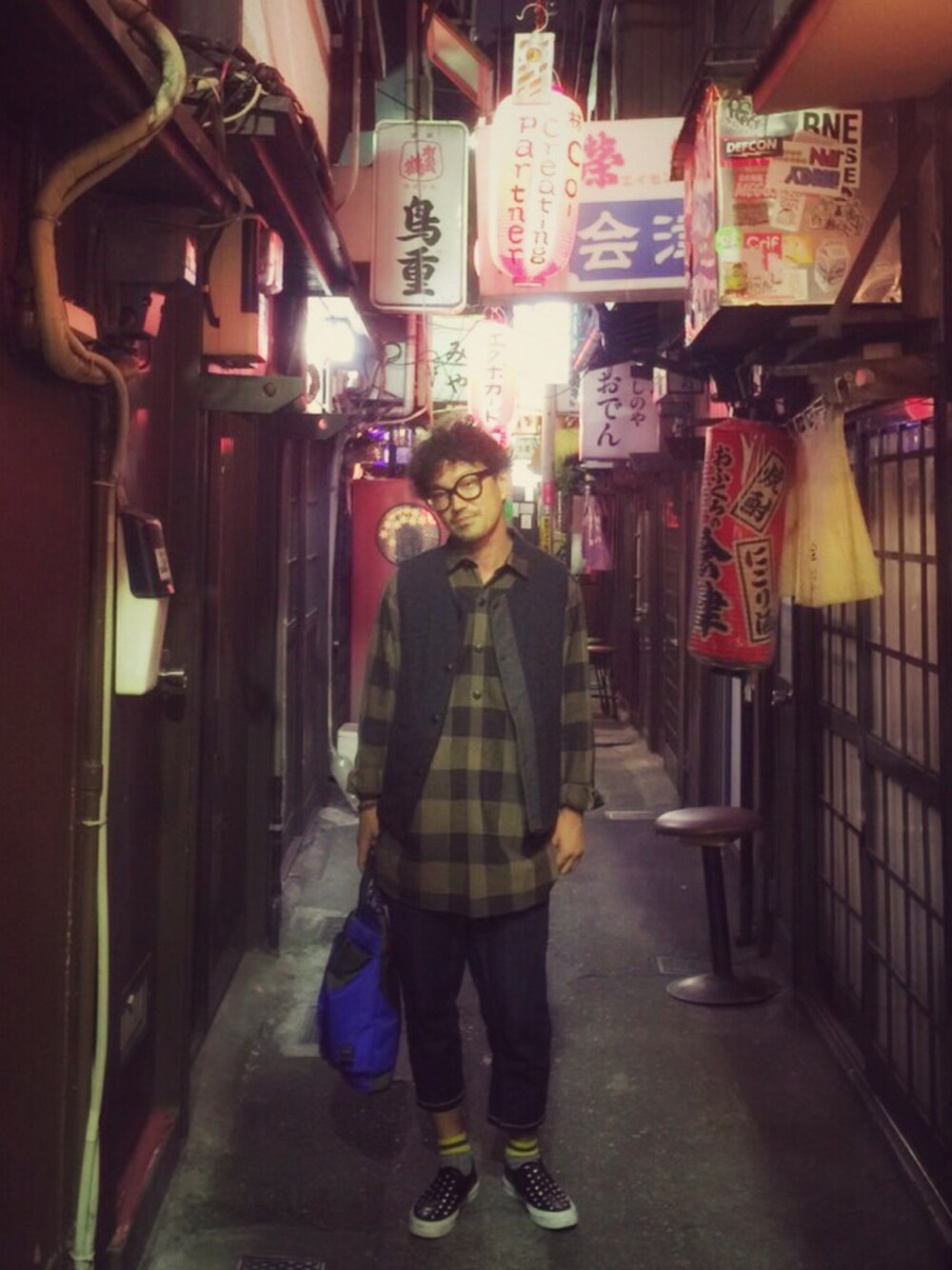 ブルー系のショルダーバッグ、ブラック系のスニーカー、ブラウン系のトップスを着用したメンズの秋コーディネートの1枚目の写真