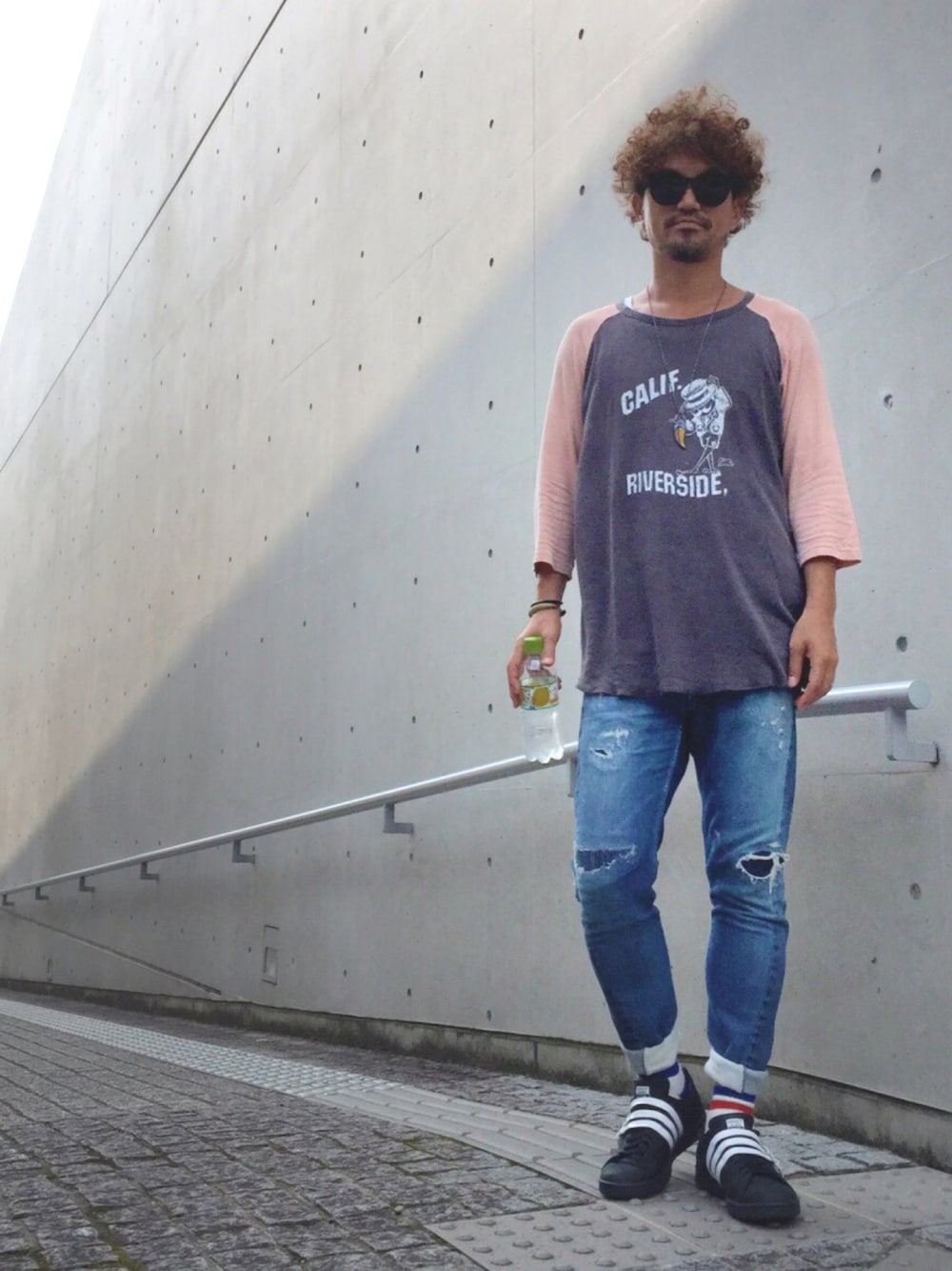 ブラック系のスニーカー、ブルー系のデニムパンツ、ブラック系のTシャツ/カットソーを着用したメンズの夏コーディネートの1枚目の写真