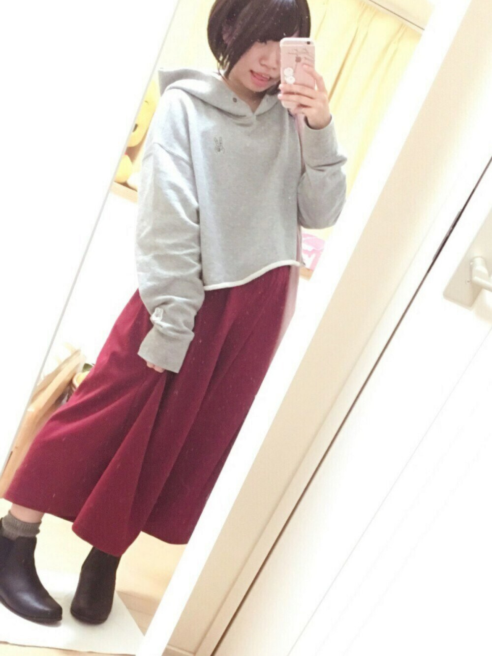 グレー系のスウェット、レッド系のパンツ、ブラック系のブーツを着用したレディースの秋コーディネートの1枚目の写真