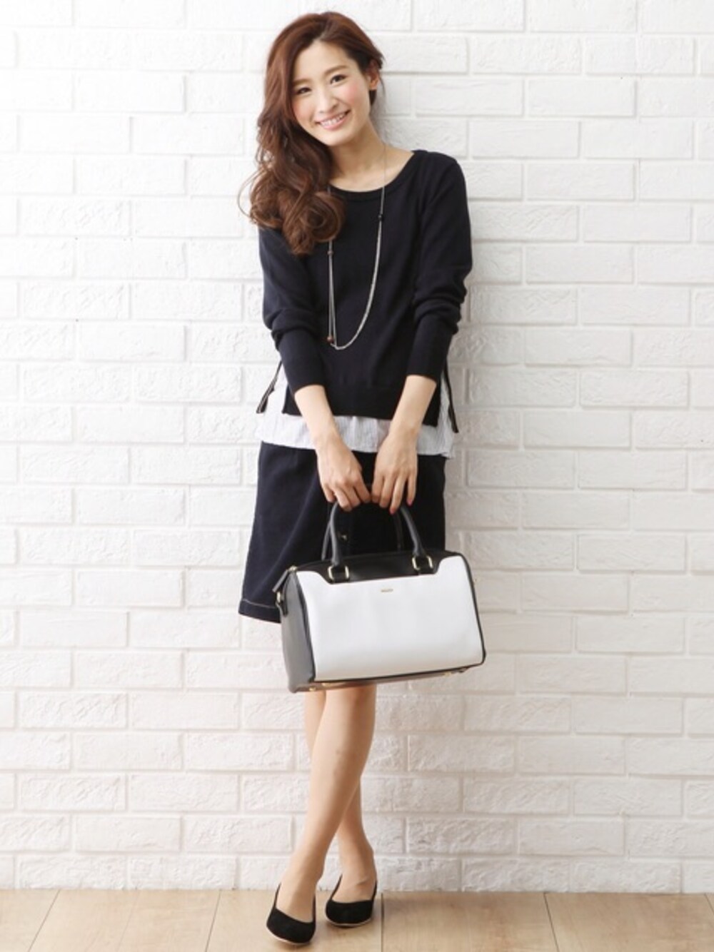 ホワイト系のボストンバッグ、ブルー系のニット/セーター、その他のスカートを着用したレディースの春コーディネートの1枚目の写真