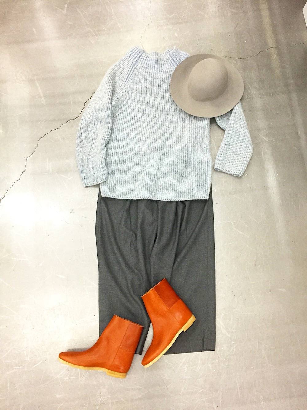 ブルー系のニット/セーター、ブラウン系のブーツ、グレー系のスラックスを着用したメンズの秋コーディネートの1枚目の写真