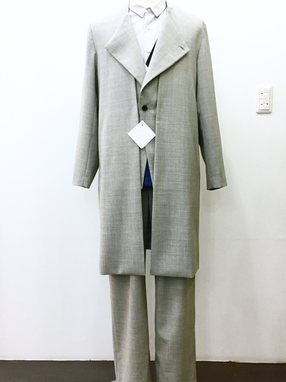 グレー系のノーカラージャケット、グレー系のその他パンツ、ブルー系のシャツ/ブラウスを着用したメンズの冬コーディネートの1枚目の写真