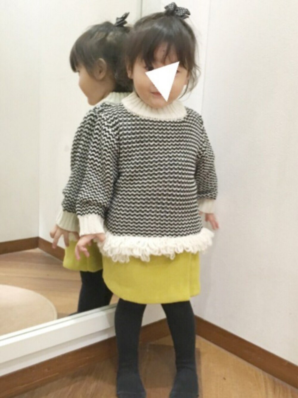 イエロー系のスカート、ホワイト系のニット/セーターを着用したキッズの秋コーディネートの1枚目の写真