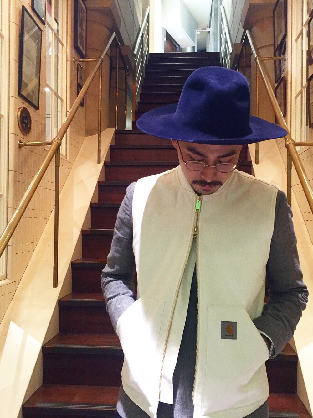 ホワイト系のダウンベスト、ブルー系のハットを着用したメンズの秋コーディネートの1枚目の写真