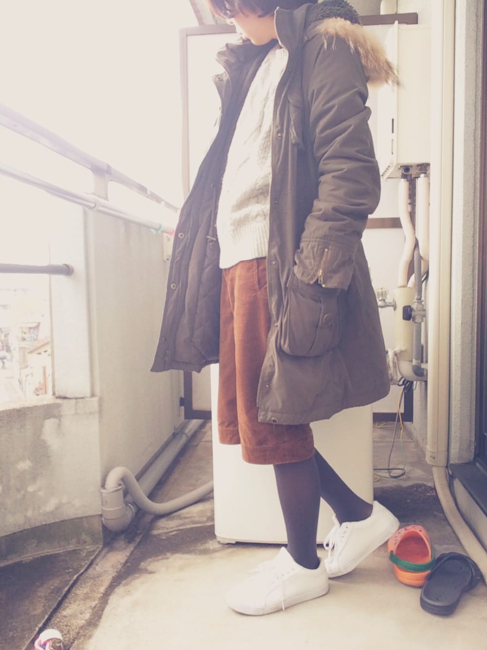 グリーン系のモッズコート、グレー系のニット/セーター、ブラウン系のパンツを着用したレディースの冬コーディネートの1枚目の写真