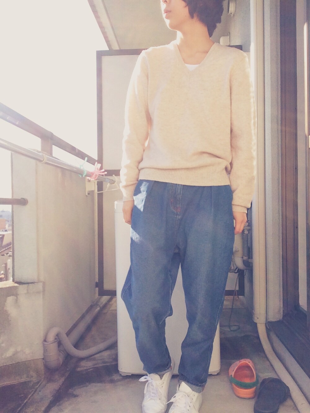 イエロー系のムートンコート、ブルー系のデニムパンツ、ホワイト系のスニーカーを着用したレディースの冬コーディネートの1枚目の写真